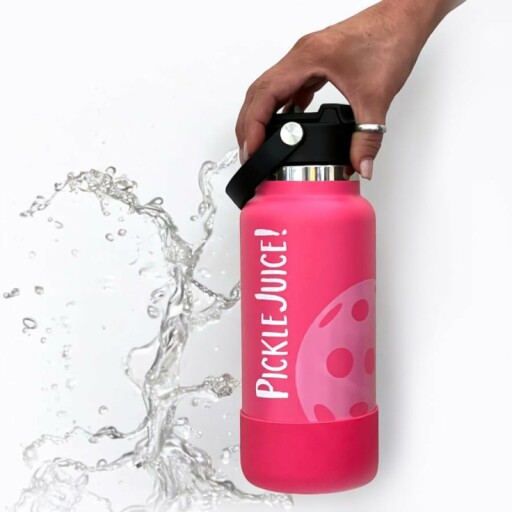 Woman holding a pink water bottle with a pickleball paddle in the background