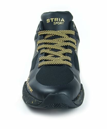 Front view of black sneaker with gold laces and STRIA SPORT logo.