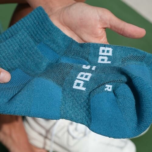 Person holding a pair of blue socks.