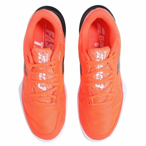 Top view of bright orange sneakers with black accents.