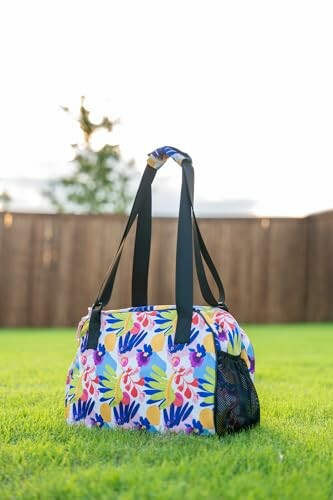 Colorful floral pet carrier on grass