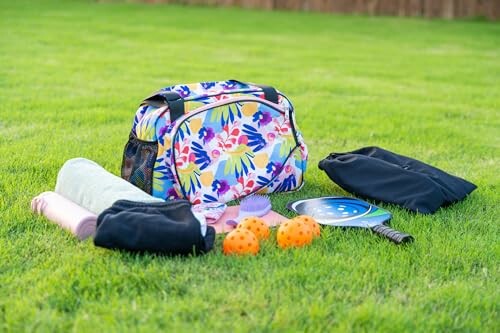 Colorful gym bag with sports equipment on grass.