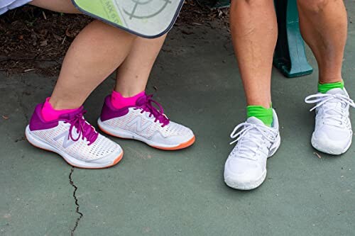 People wearing colorful tennis shoes on a court.