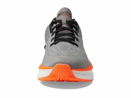 Front view of a gray and orange running shoe