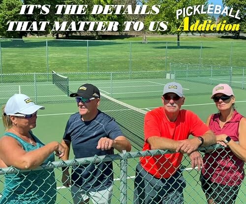 Group of people standing by a pickleball court fence.