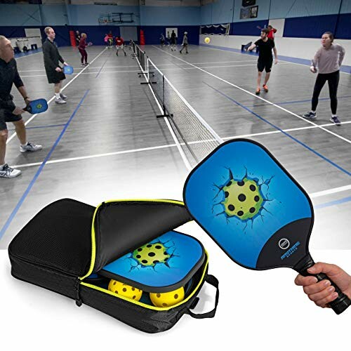 Indoor pickleball game with players and equipment.