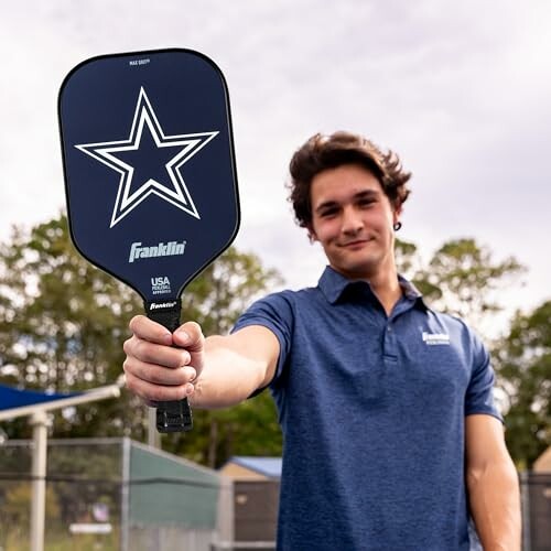 Man holding a Franklin pickleball paddle outdoors