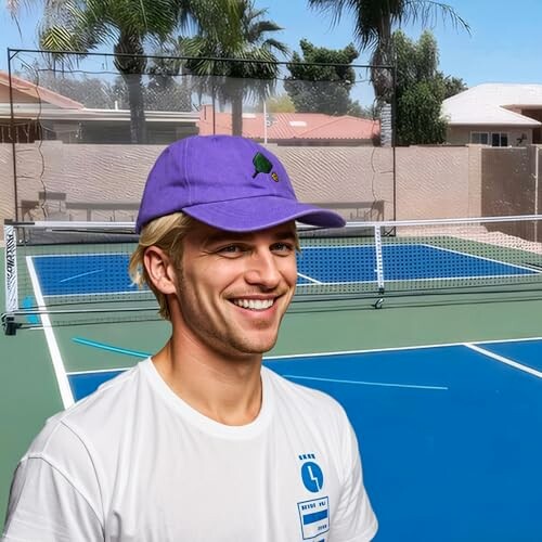 Smiling man in purple cap on tennis court