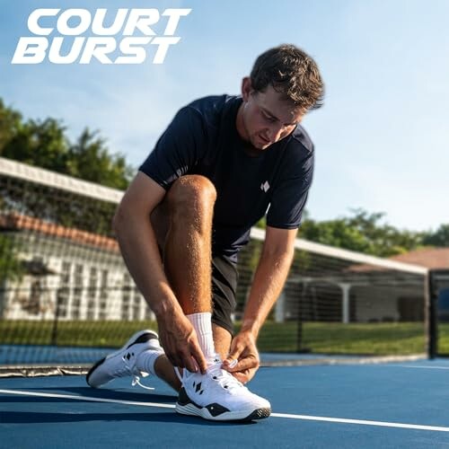 Man tying shoe on tennis court