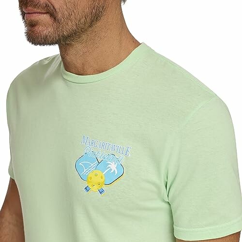 Man wearing a light green Margaritaville pickleball t-shirt.