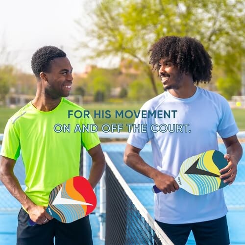 Two men holding pickleball paddles on a court.