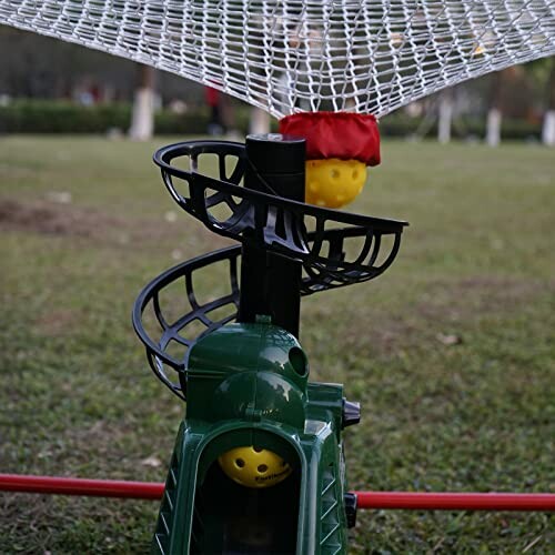 Outdoor toy with spiral track and yellow ball under net.