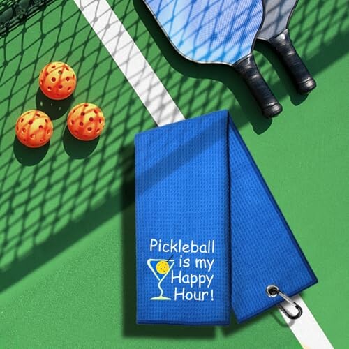 Pickleball paddles, balls, and blue towel with 'Pickleball is my Happy Hour!' text.