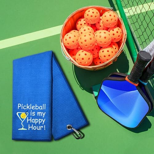 Pickleball paddle, balls, and towel on court.