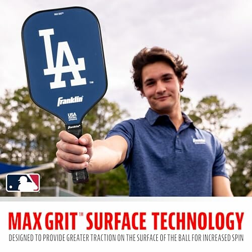 Person holding a pickleball paddle with Max Grit technology.