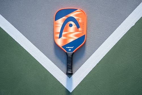 Pickleball paddle on court surface with geometric design.