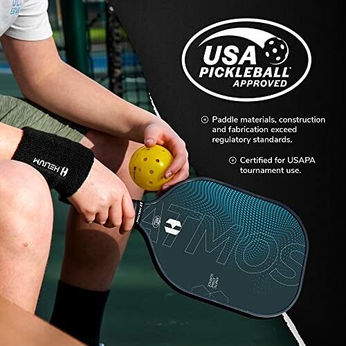 Person holding a pickleball paddle and ball, USA Pickleball approved.