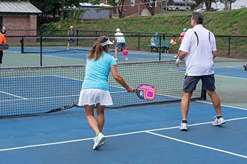 People playing pickleball on an outdoor court.