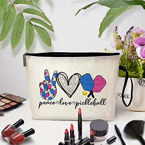 Cosmetic bag with peace, love, pickleball design surrounded by makeup items