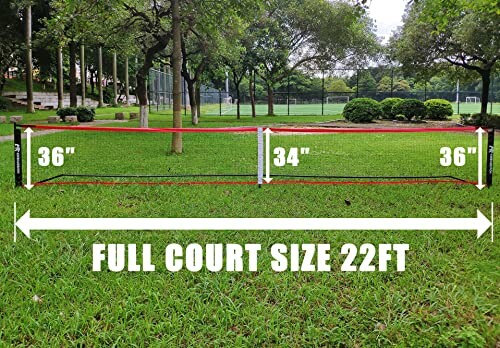 Portable badminton net setup on grass with court size dimensions.