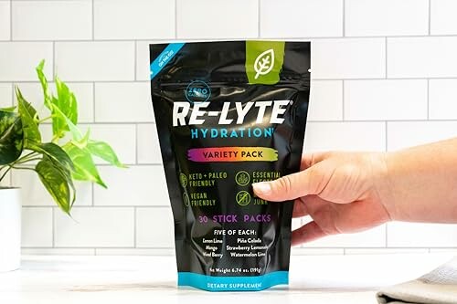 Hand holding a packet of Re-Lyte Hydration Variety Pack.